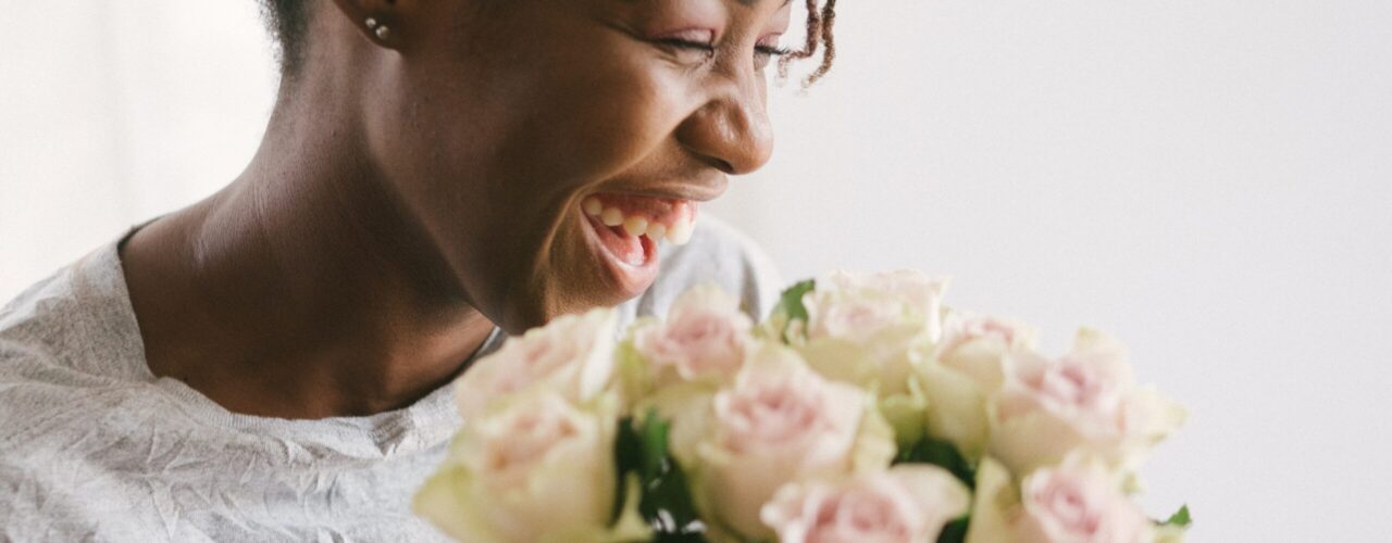 Happy black woman holding roses