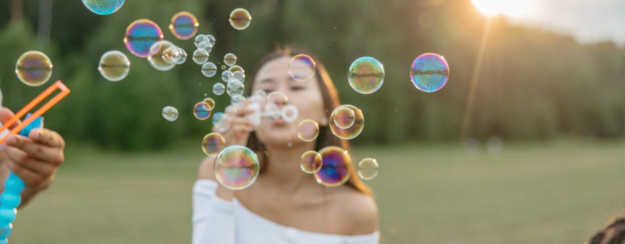 Woman blowing bubbles in park